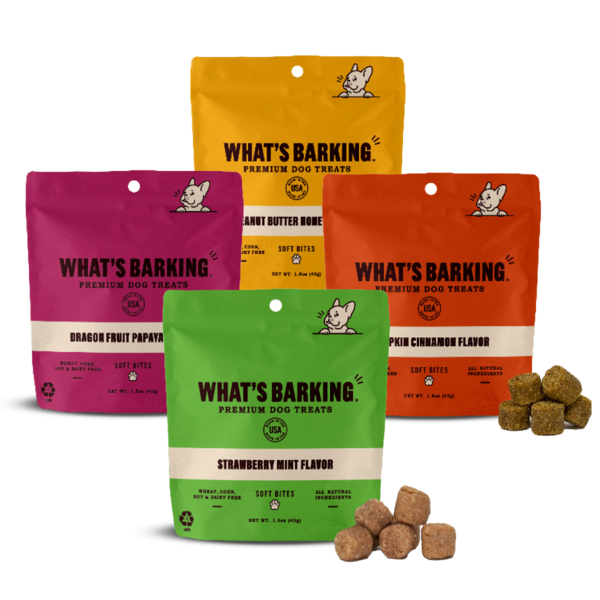 Four bags of What's Barking Premium Dog Treats in strawberry mint, dragon fruit papaya, peanut butter honey, and pumpkin cinnamon flavors, with soft bite treats displayed in front