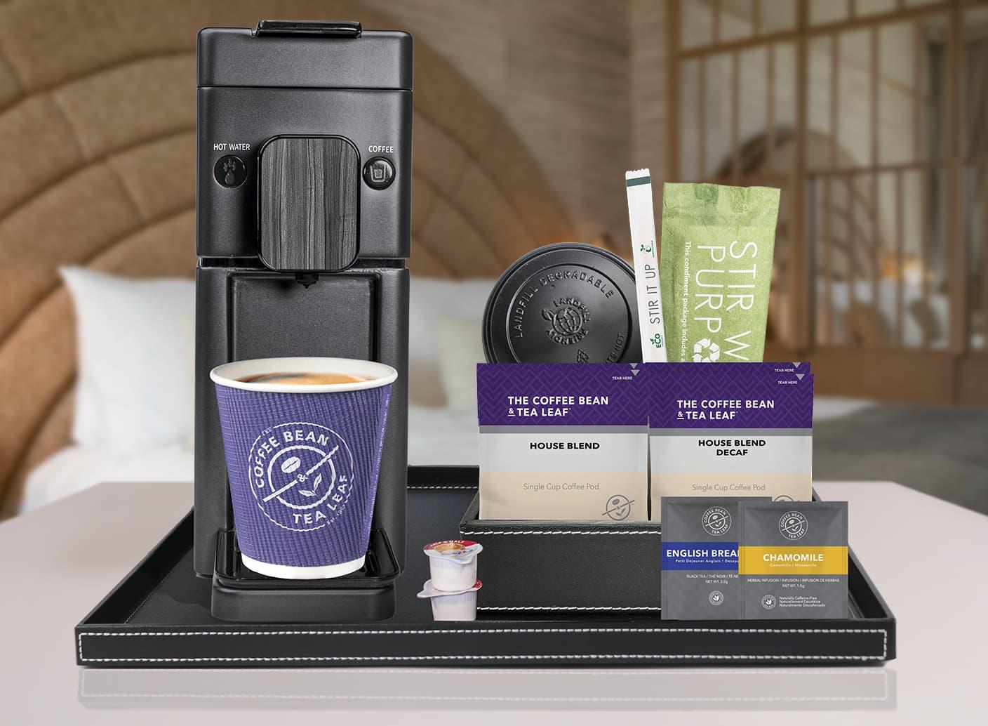 Coffee Bean & Tea Leaf single-serve coffee maker with House Blend pods and tea sachets on hotel room tray