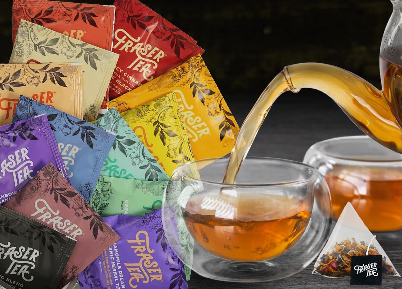 Fraser Tea assorted tea sachets fanned out beside glass teacups being filled from a teapot