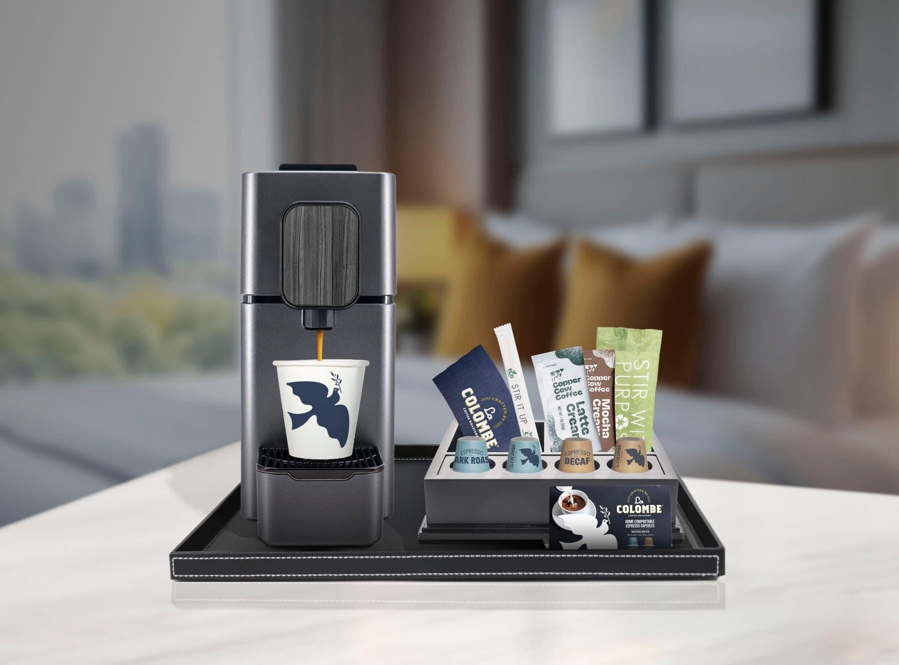 La Colombe Nespresso-compatible espresso machine with dark roast capsules and Copper Cow creamers on hotel room tray